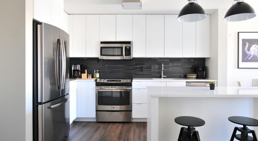 Fully furnished corporate housing kitchen with modern appliances, cookware, and dining essentials for extended stay travelers.