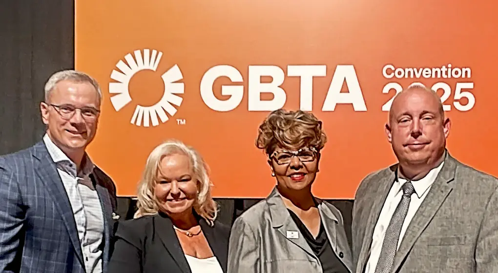 Image of four smiling executives in front of an orange banner that reads GBTA Convention 2025. From left to right, the executives are: Ryan Guthrie, Corpay’s Group President, Lodging; Leigh Ann Vernon, Director, Strategic Sourcing and Supply for BNSF Railway; Mechell Hoxie, Head of Global Sales for Sonesta; and Chris McLaughlin, Senior Director of National Sales for Aimbridge Hospitality.