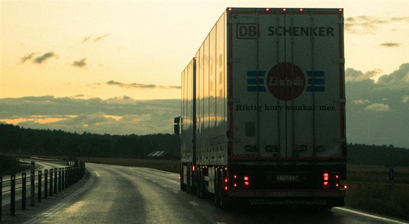 Photo of the back of a tractor trailer driving into the sunset on a lonely summer highway. The truck driver is probably looking for a hotel and hoping it isn’t overbooked.